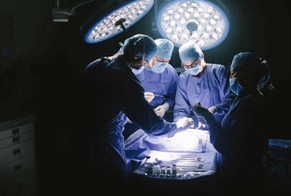 4 medical professionals pictured preparing a patient for surgery