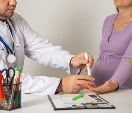 OB-GYN taking blood from a pregnant woman, running routine bloodwork for a safe pregnancy