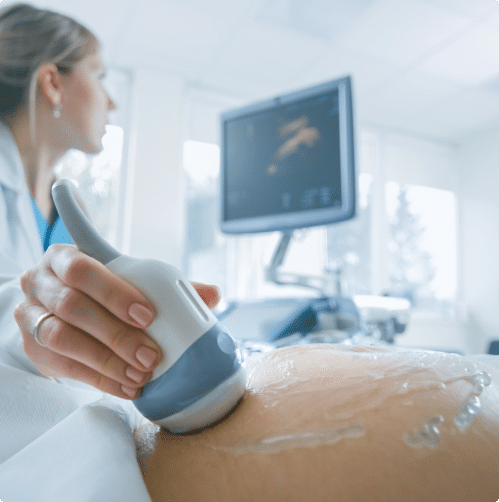 Ultrasound tech using ultrasound machine on a pregnant woman