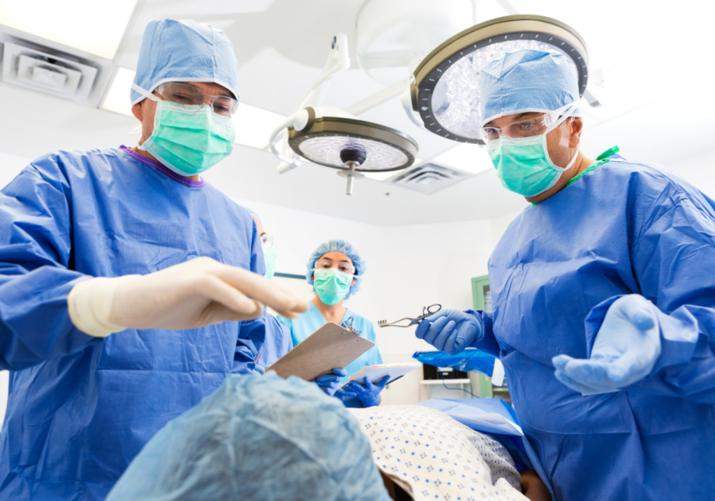 3 doctors looking at a patient during surgery
