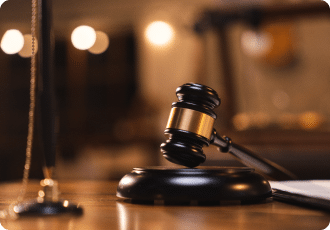 The image features a gavel, a wooden ceremonial mallet used by judges.